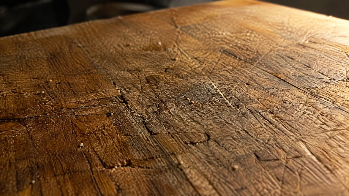 Nahaufnahme eines alten Holzbretts mit tiefen Messerrillen